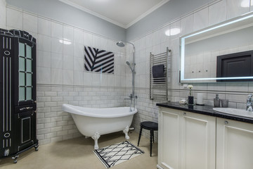 Nice stylish bathroom with cupboard, mirror and tub