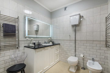 Beautiful modern bathroom with large backlit illuminated mirror