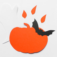 Halloween decorations with paper pumpkins, bats, candles and ghosts on white background. Halloween and decoration concept. Flat lay, top view