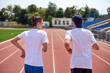 Young athletes having a talk while racing on the running track