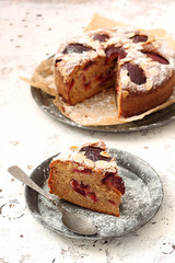 Delicious plum pie with piece of pie on the rustic background