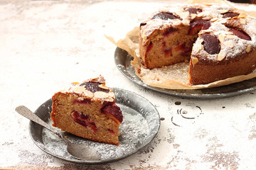 Delicious plum pie with piece of pie on the rustic background