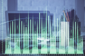 Stock market graph on background with desk and personal computer. Multi exposure. Concept of financial analysis.