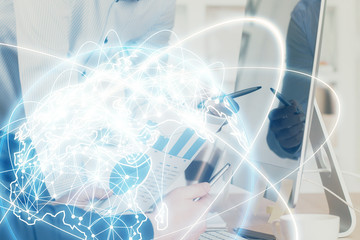 Double exposure of businessman working on laptop on background. International business hologram in front. Concept of success.