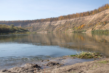 Autumn landscape.  A large slope in the distance and a transparent, wide river.