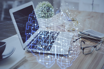 Double exposure of desktop with computer and brain drawing hologram. Artificial intelligence...