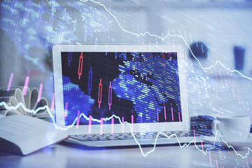 Stock market graph on background with desk and personal computer. Double exposure. Concept of financial analysis.