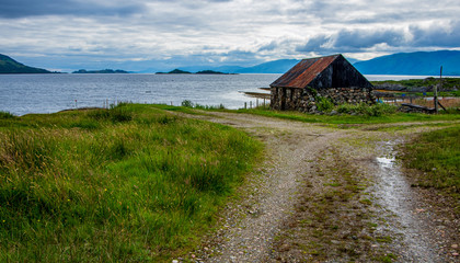 Fototapeta na wymiar Stone and corrugated iron fisherman's hut in beautiful scenery
