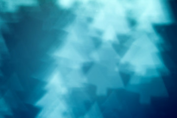 Fototapeta premium Blurred blue background with bokeh in the shape of fir tree. Abstract texture with soft focus