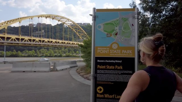 Mature woman looks at map kiosk at Point State Park in Pittsburgh, Pennsylvania.