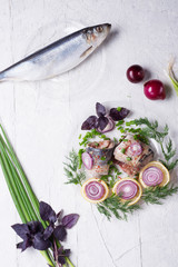 marinated herring roll fillet on a transporant plate with green onion, lemon  and seasonings. served in Scandinavian style. Typical cooking fish in Scandinavian countries. copy space