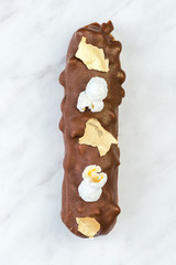 Artisan French Eclair Decorated on White Marble