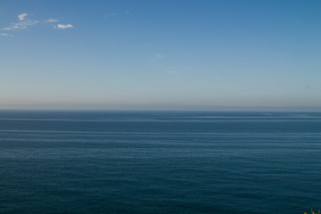 Fototapeta premium Current in the sea, top view. Shades of blue in the sea at the coastal current. Sea and sky, fifty shades of blue.