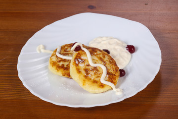 Obraz na płótnie Canvas Tasty cheesecakes with sour cream