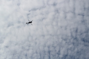 large military helicopter hovers in sky. A camouflaged helicopter flies at high speed.