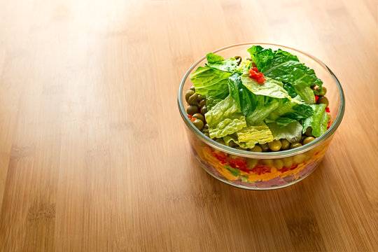 Healthy Five Layer Salad Bowl On A Light Wood Surface