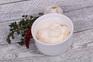Mayonnaise sauce in the white bowl served thyme and garlic