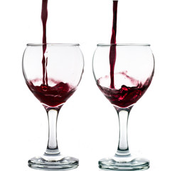 Pouring red wine into the glass against white background