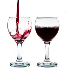 Pouring red wine into the glass against white background
