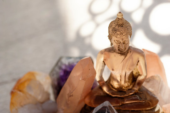 Transluscent pink Buddha statue with healing Reike crystals. 