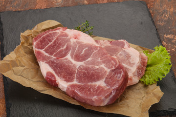 Raw pork steak over wooden board