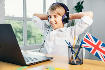 Smiling enthusiastic boy is satisfied with his progress in learning english