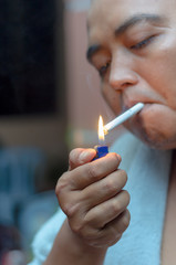 Fototapeta premium Man lighting up cigarette