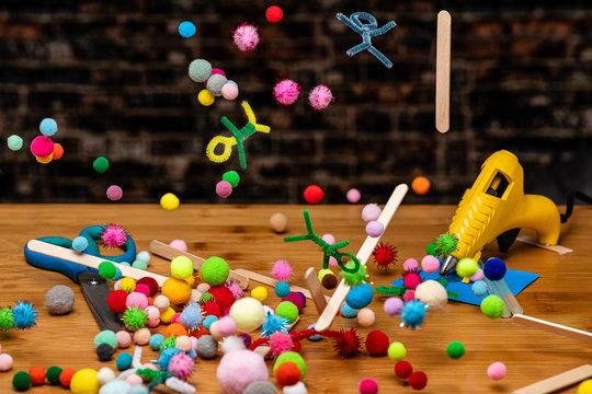 Crafting and Scrapbooking Supplies falling to a wooden table work surface in a rainfall of color - Powered by Adobe