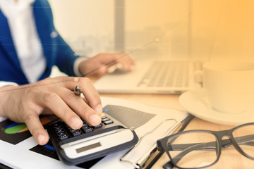 Fototapeta premium Business accounting plan concept, Working on desktop laptop computer with calculator for making business, business man hand working with laptop computer on wooden desk business investment advisor.