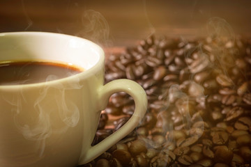 Hot white cup of fresh coffee, cappuccino with Golden fragrant smoke.  sack and beans on background.