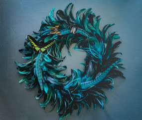 Teal peacock feather wreath with colorful butterflies