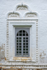 An ancient window in a brick white wall