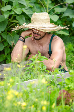 portrait of bearded man with straw hat relaxing in garden