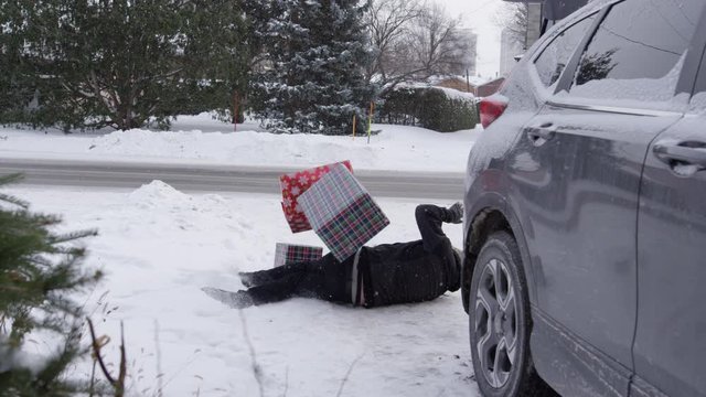 Man slips on ice carrying Christmas gifts