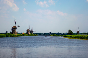 Fototapeta na wymiar Traditional Dutch windmills scattered around the canals in Kinderdijk, Netherlands.