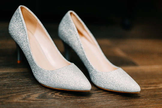 Close-up of the bride silver shoes on the floor, selective focus