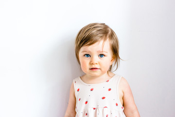 Serious thoughtful attentive child toddler girl against white background