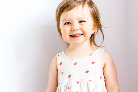 Happy smiling funny toddler child girl on white background