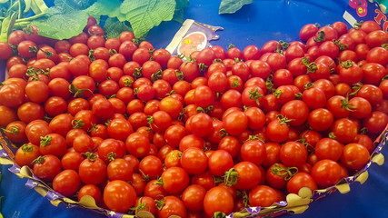 Naklejka na ściany i meble little red fresh ripe tomatoes background at the fruit market stand