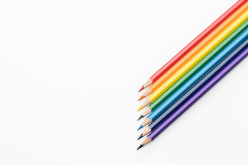 Rainbow color pencils in the form of an arrow from the right corner top view copy space