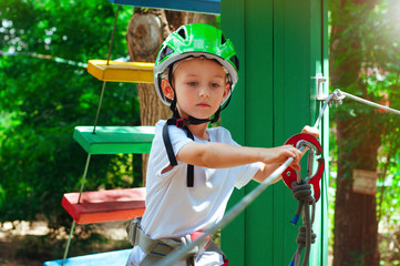 A little boy exploring an adventure rope park