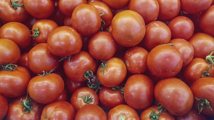 little red fresh ripe tomatoes background at the fruit market stand
