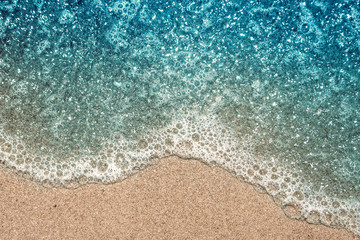 Fototapeta na wymiar The azure wave and the sandy shore