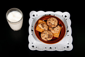 milk and cookies on black background