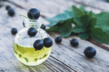 Black currant extract in a glass bottle. Medicinal tincture with black currant.