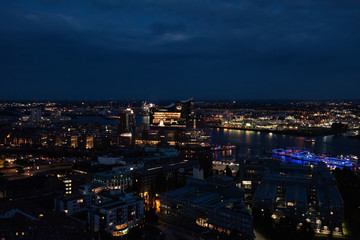 View of the harbor and the new Elbphilharmony of Hamburg with boats at night