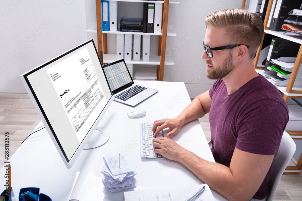 Poster businessman checking invoice on computer