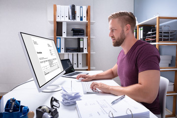 Businessman Checking Invoice On Computer