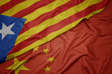 waving colorful flag of china and national flag of catalonia.