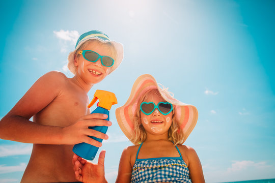 sun protection, cute girl and boy with sun cream at beach